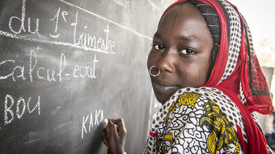 Kaka Marabou skriver sit navn på skolens tavle i Yakoua, Tchad-søen. Flygtninge, fordrevne og andre fattige samfund i Tchad-søens bassin er afhængige af humanitær bistand for at overleve og adgangen til grundlæggende uddannelse er også begrænset. WFP/Giulio d'Adamo