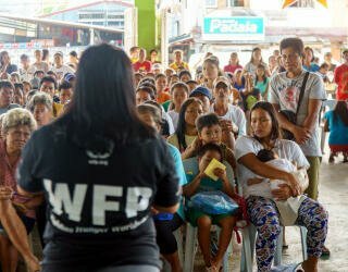 WFP-medarbejdere forklarer registreringsprocessen til de medlemmer af Irosin-samfundet, der deltager i det prognosebaserede finansieringsprojekt. Foto: WFP Filippinerne/Arete