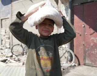 Syrien, Aleppo. Børn stiller sig i kø sammen med deres forældre eller sendes alene ud for at hente brød inden de går i skole. Foto: WFP/Hussam Al Saleh