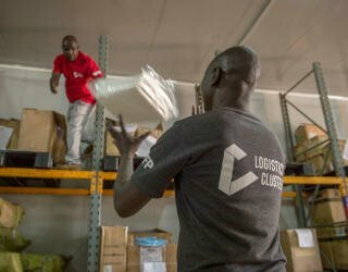 Logistikmedarbejdere kontrollerer personligt beskyttelsesudstyr (PPE), der er ved at blive aflæsset på det temperaturkontrollerede lager i Lologo, Juba. Foto: WFP/Giulio d'Adamo