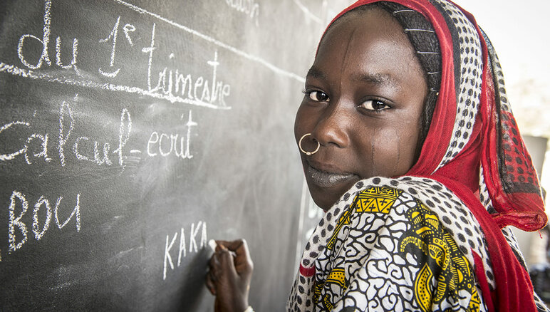 Kaka Marabou skriver sit navn på skolens tavle i Yakoua, Tchad-søen. Flygtninge, fordrevne og andre fattige samfund i Tchad-søens bassin er afhængige af humanitær bistand for at overleve og adgangen til grundlæggende uddannelse er også begrænset. WFP/Giulio d'Adamo
